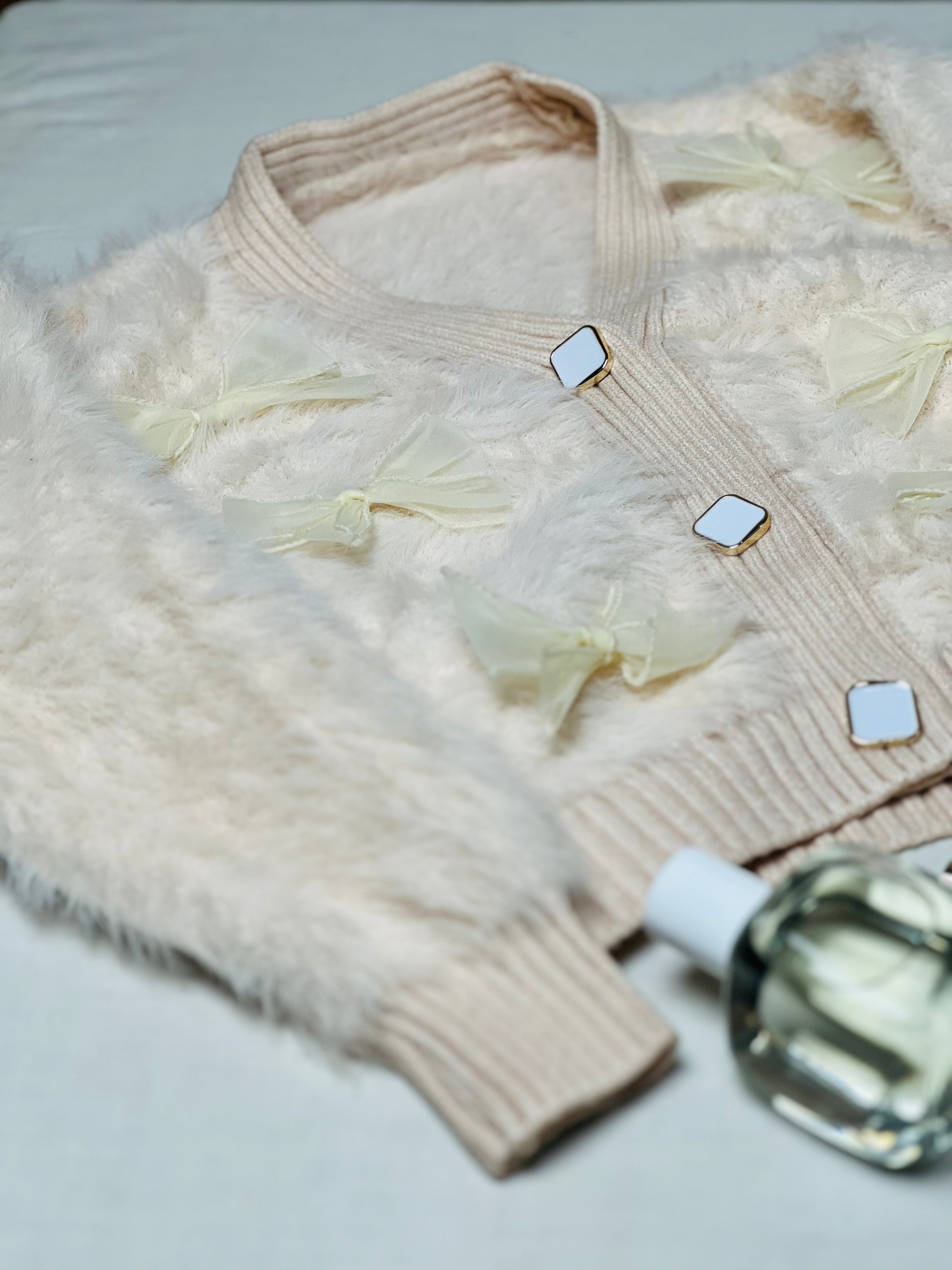 Beige fur woollen cardigan with charming bow accents for winter wear