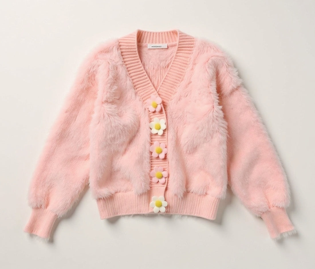 Pastel striped cardigan with floral buttons on a soft pink background, labeled 'Cozy Knits'.