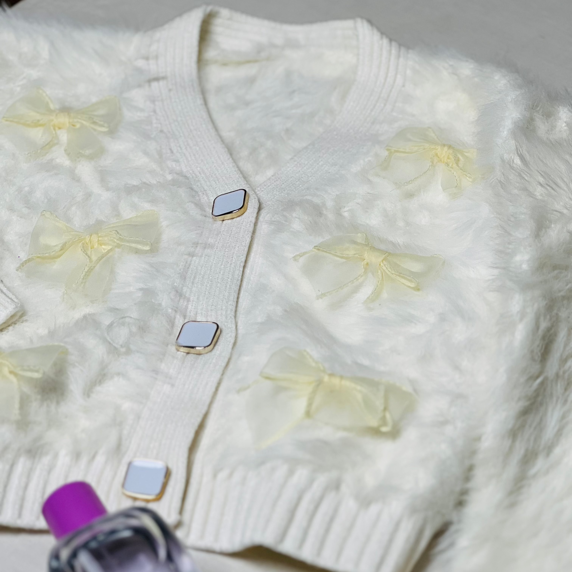 Long-sleeve white cardigan with bows and a fuzzy texture